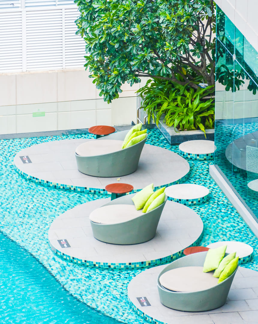 Grupo Econstrucciones - Piscina con asientos de mimbre y vegetación, remodelación zen